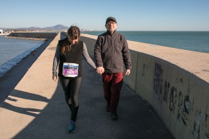 L'atleta solidària de la Marató de Barcelona Laura Arín camina amb el seu pare pel port de Barcelona